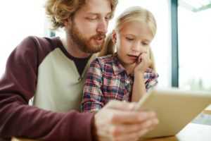 Forældre hjælper barn på digitale medier